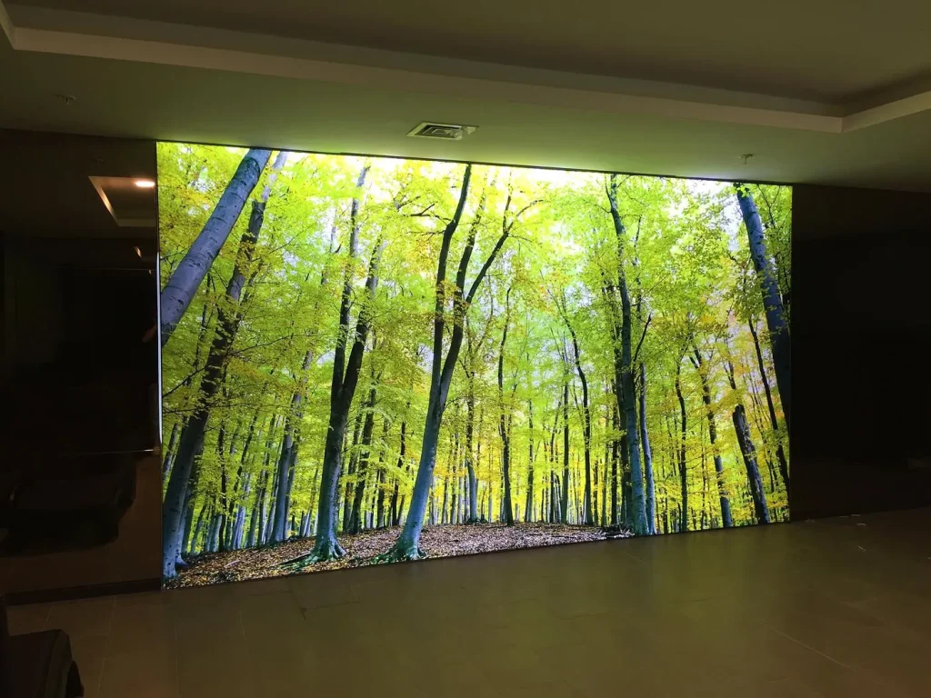 Large-format edge-lit lightbox with illuminated forest graphic at Körfez GYO thermal centre